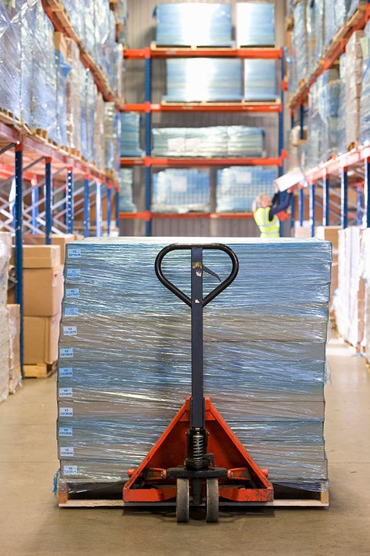 Ladungssicherung von Paletten im Lager mit Stretchfolie und Hubwagen