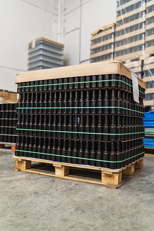 Ladungssicherung von Paletten mit gestapelten Glasflaschen auf Holzpalette